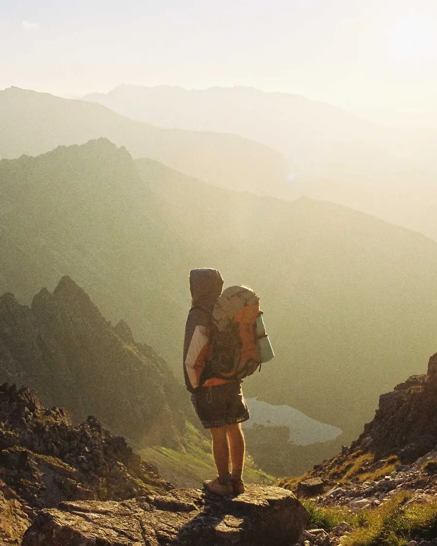 Hiker on a mountain trail above a lake